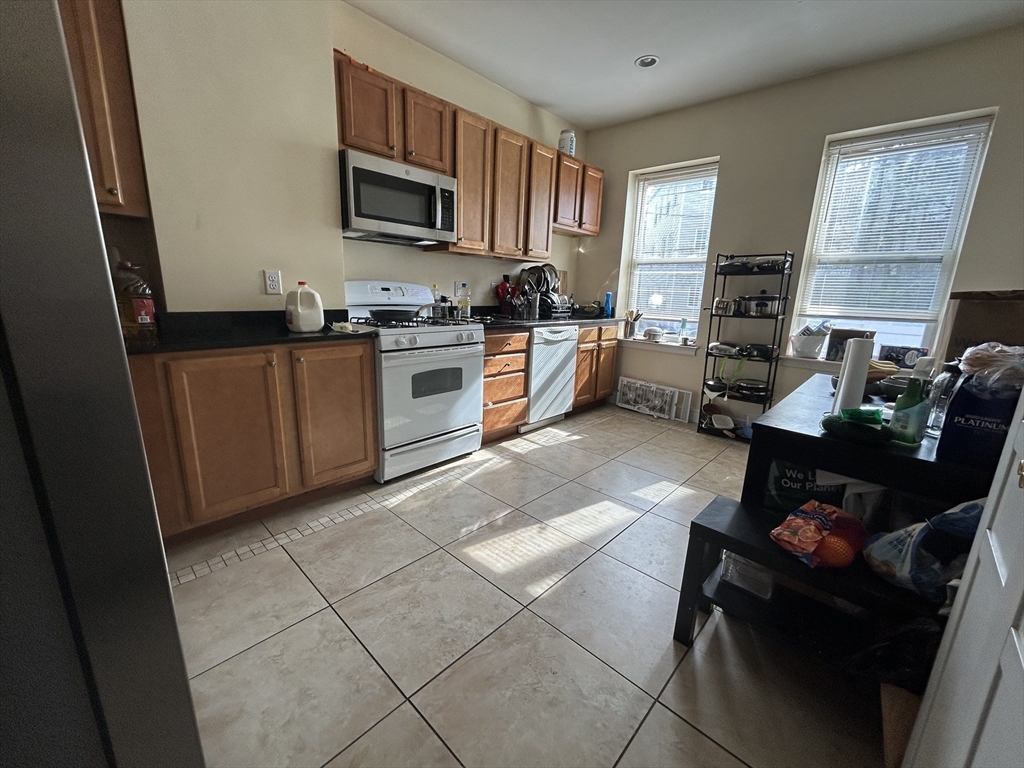 191 Boylston Street, Unit 1 Boston, MA 02130 - Photo 3 of 13 a kitchen with stainless steel appliances granite countertop a stove a sink and a refrigerator