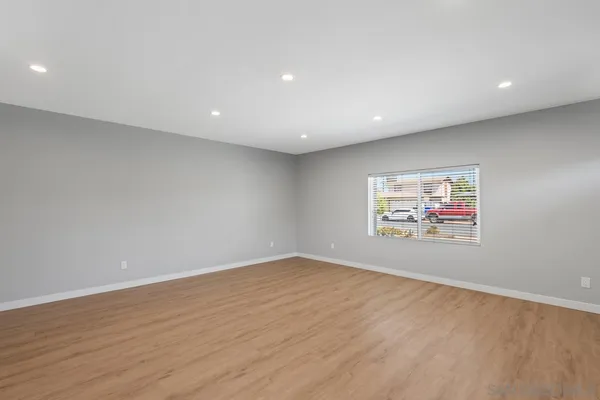 a view of an empty room with wooden floor and closet