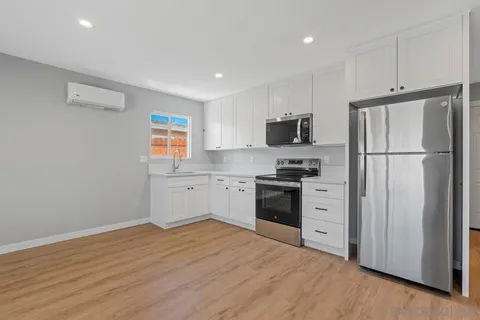 a kitchen with cabinets appliances a sink and a window