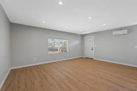 a view of an empty room with wooden floor and closet