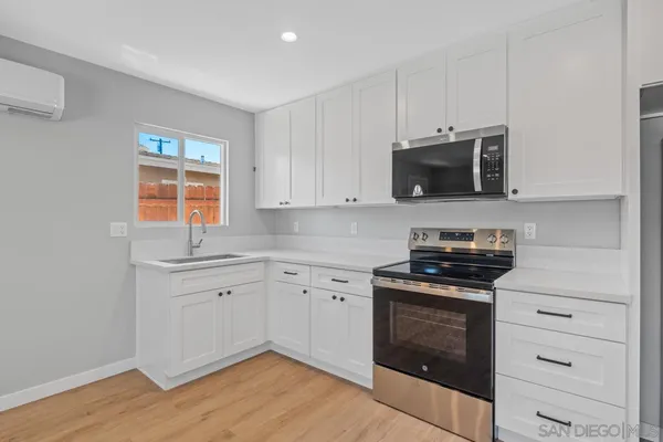 a bathroom with a toilet a sink a mirror a vanity and shower