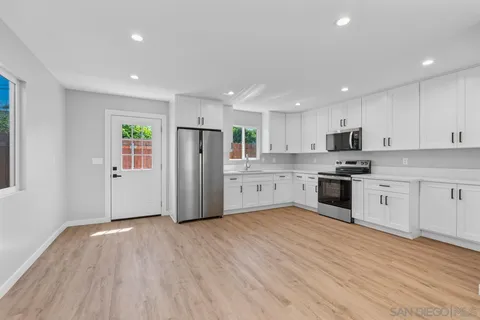 a view of an empty room with wooden floor & closet