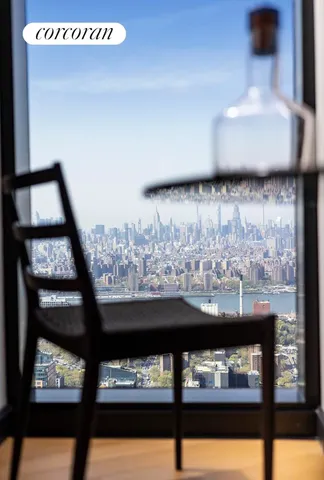 a living room with furniture potted plant and kitchen view