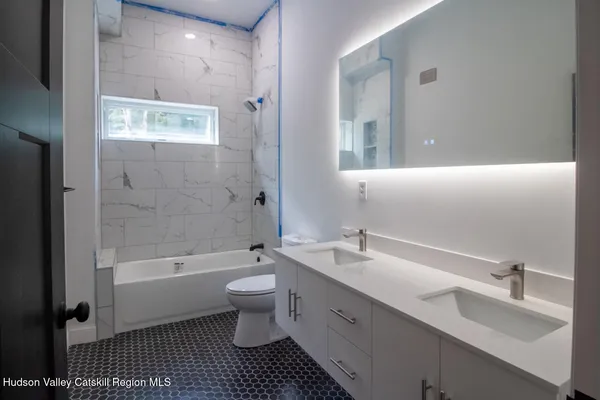 a bathroom with a double vanity sink toilet and shower