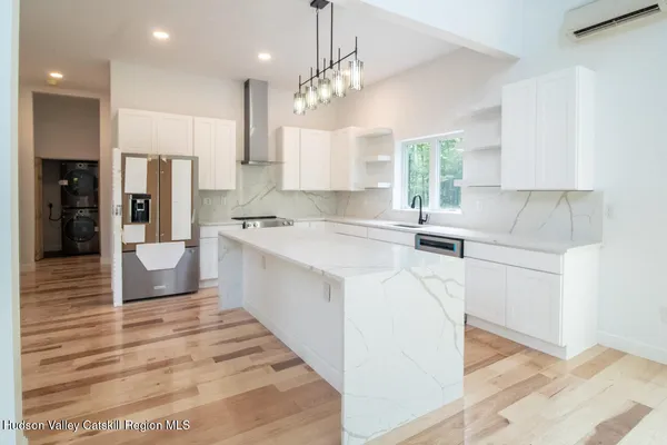 a kitchen with kitchen island a sink stainless steel appliances and cabinets
