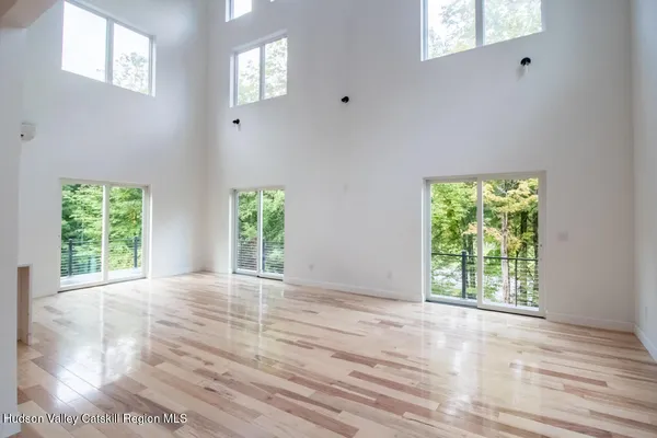 a view of a living room and kitchen with furniture wooden floor and windows