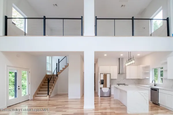 a view of a hallway with wooden floor and a kitchen