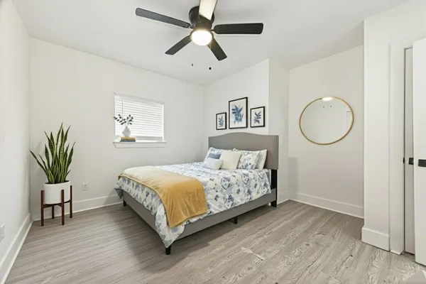 a bedroom with a bed chandelier and a window