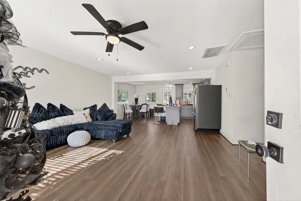 a living room with furniture and a wooden floor