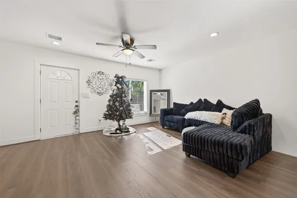 a living room with furniture and wooden floor