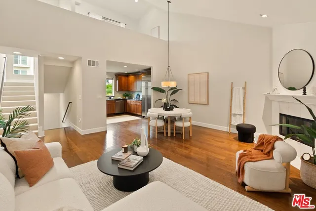 a living room with furniture a fireplace and a chandelier