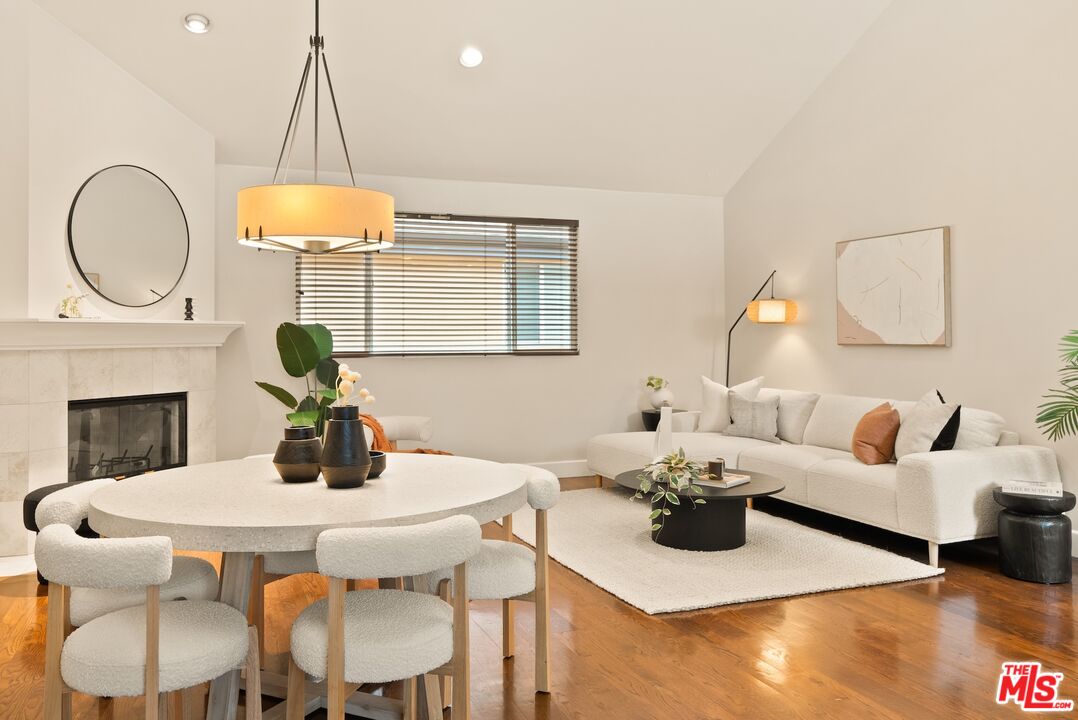 3971 Moore Street, Unit 102 Los Angeles, CA 90066 - Photo 7 of 35 a dining room with wooden floor a chandelier a wooden table and chairs