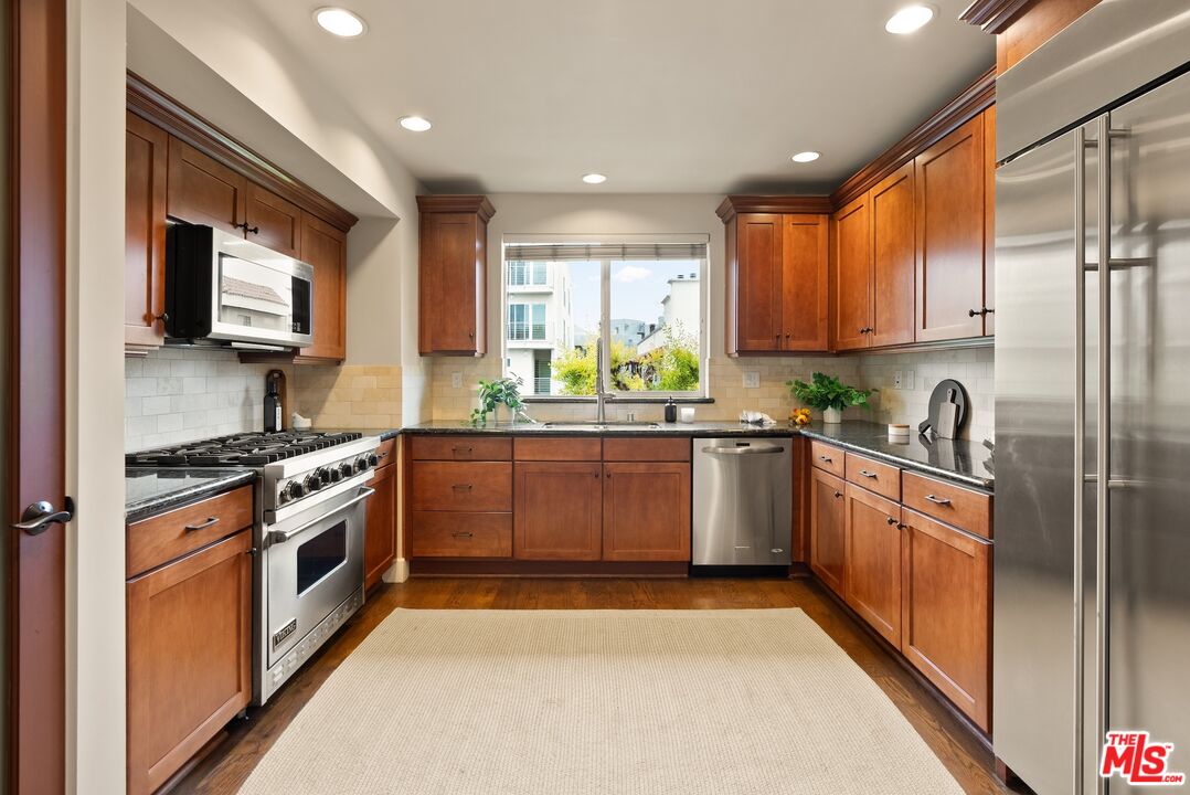 3971 Moore Street, Unit 102 Los Angeles, CA 90066 - Photo 10 of 35 a kitchen with stainless steel appliances granite countertop a stove a sink and a microwave