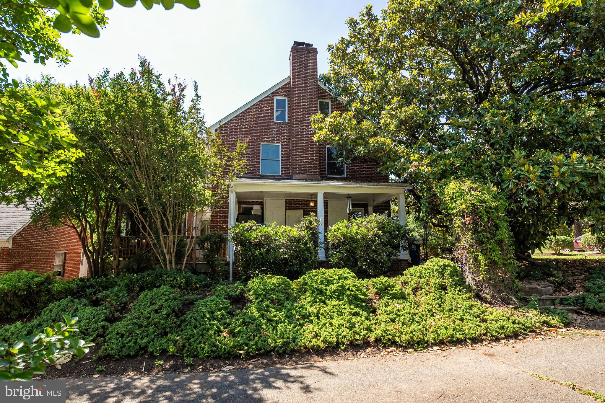 241 Edwards Ferry Road Northeast Leesburg, VA 20176 - Photo 3 of 27 Charming brick home with lush greenery.
