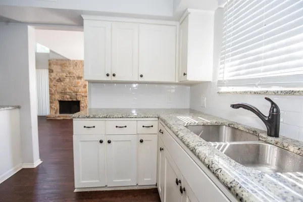 a kitchen with granite countertop a sink and a stove