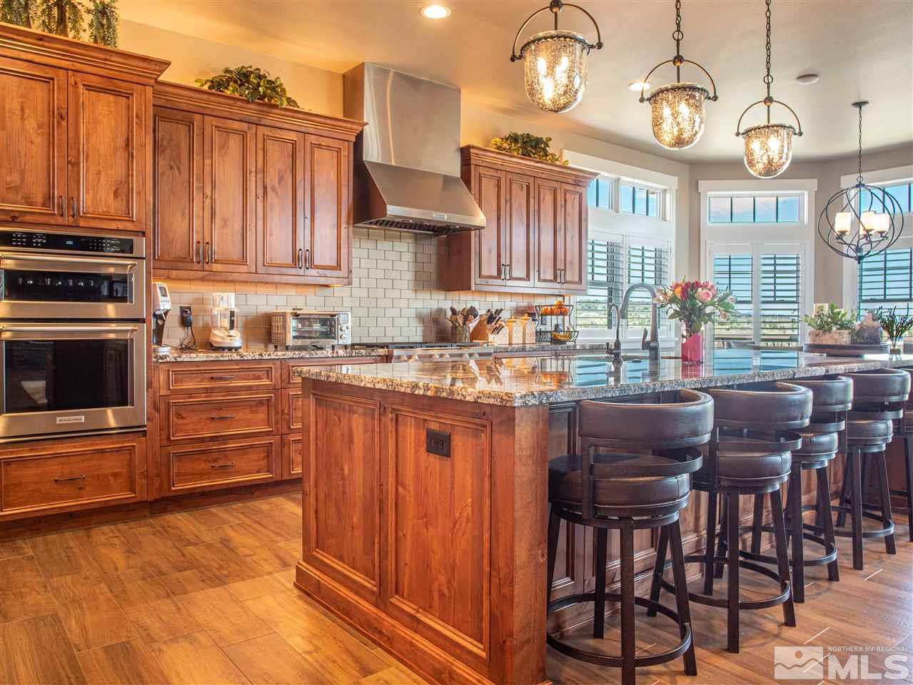 1690 Circle Stone Court Reno, NV 89523 - Photo 12 of 40 a kitchen with stainless steel appliances granite countertop a stove top oven a refrigerator a sink dishwasher and a dining table with chairs