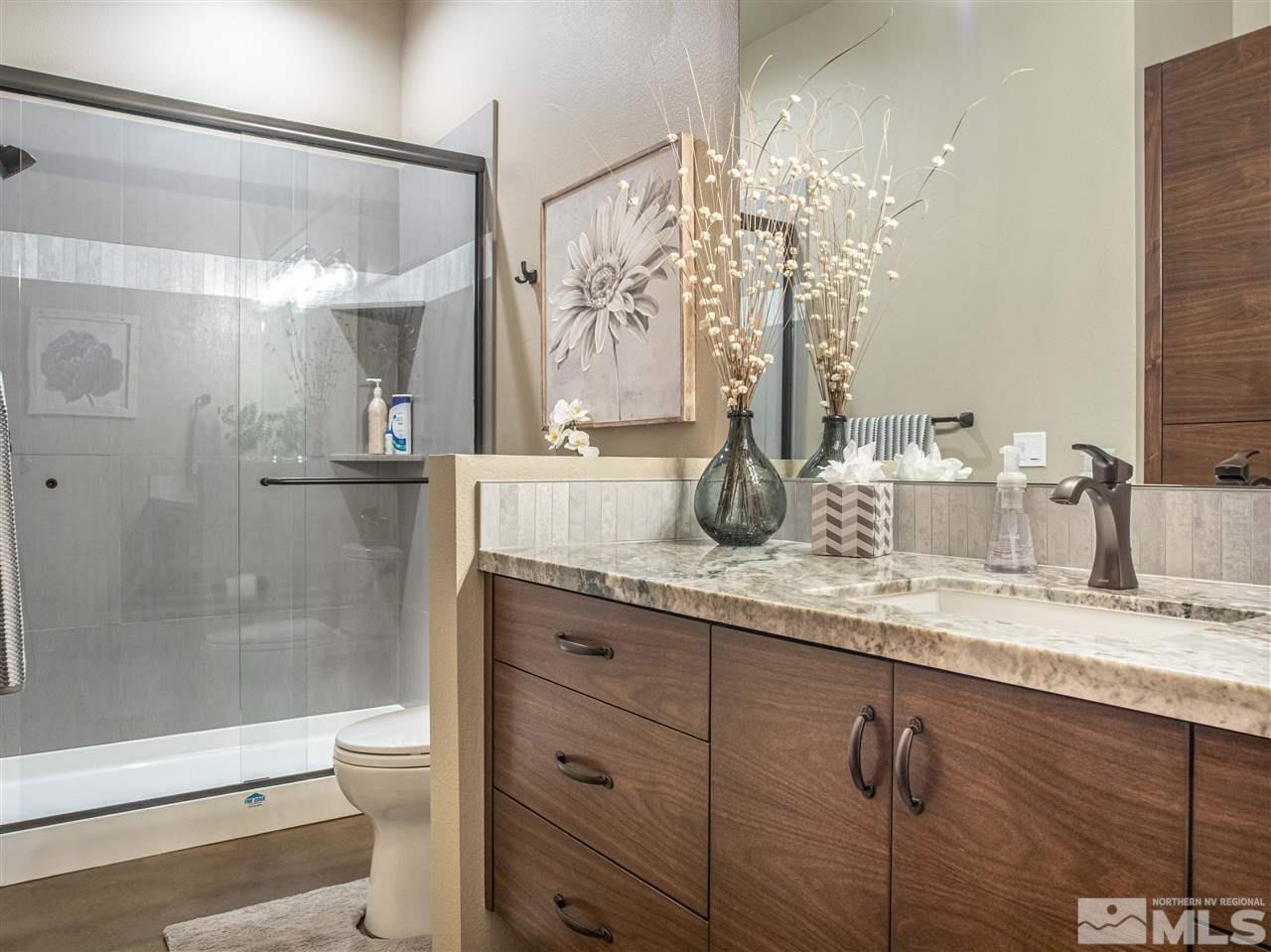 1690 Circle Stone Court Reno, NV 89523 - Photo 29 of 40 a bathroom with a granite countertop sink a toilet and shower
