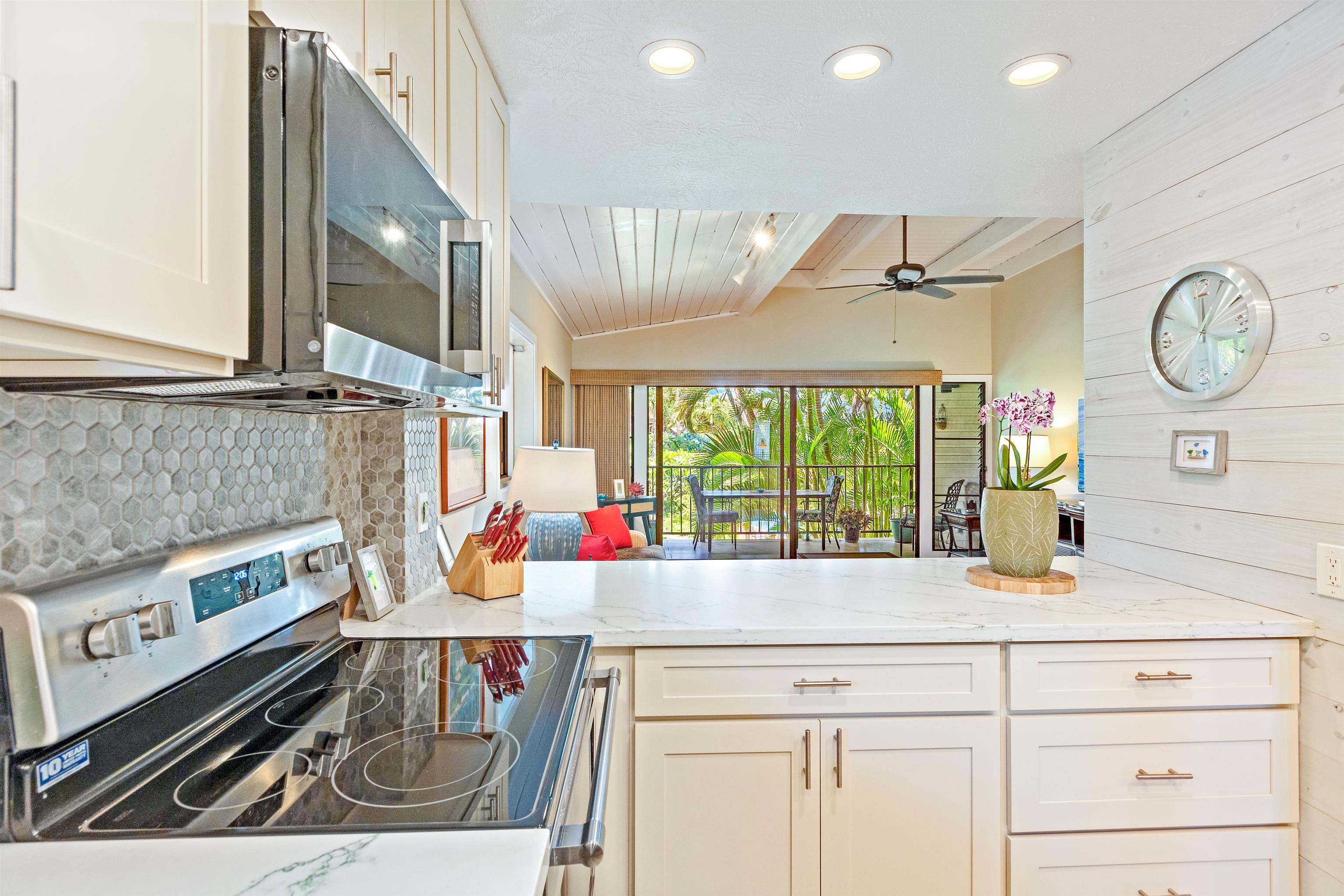 3788 Lower Honoapiilani Road, Unit D101 Lahaina, HI 96761 - Photo 11 of 40 a kitchen with a large window appliances and cabinets
