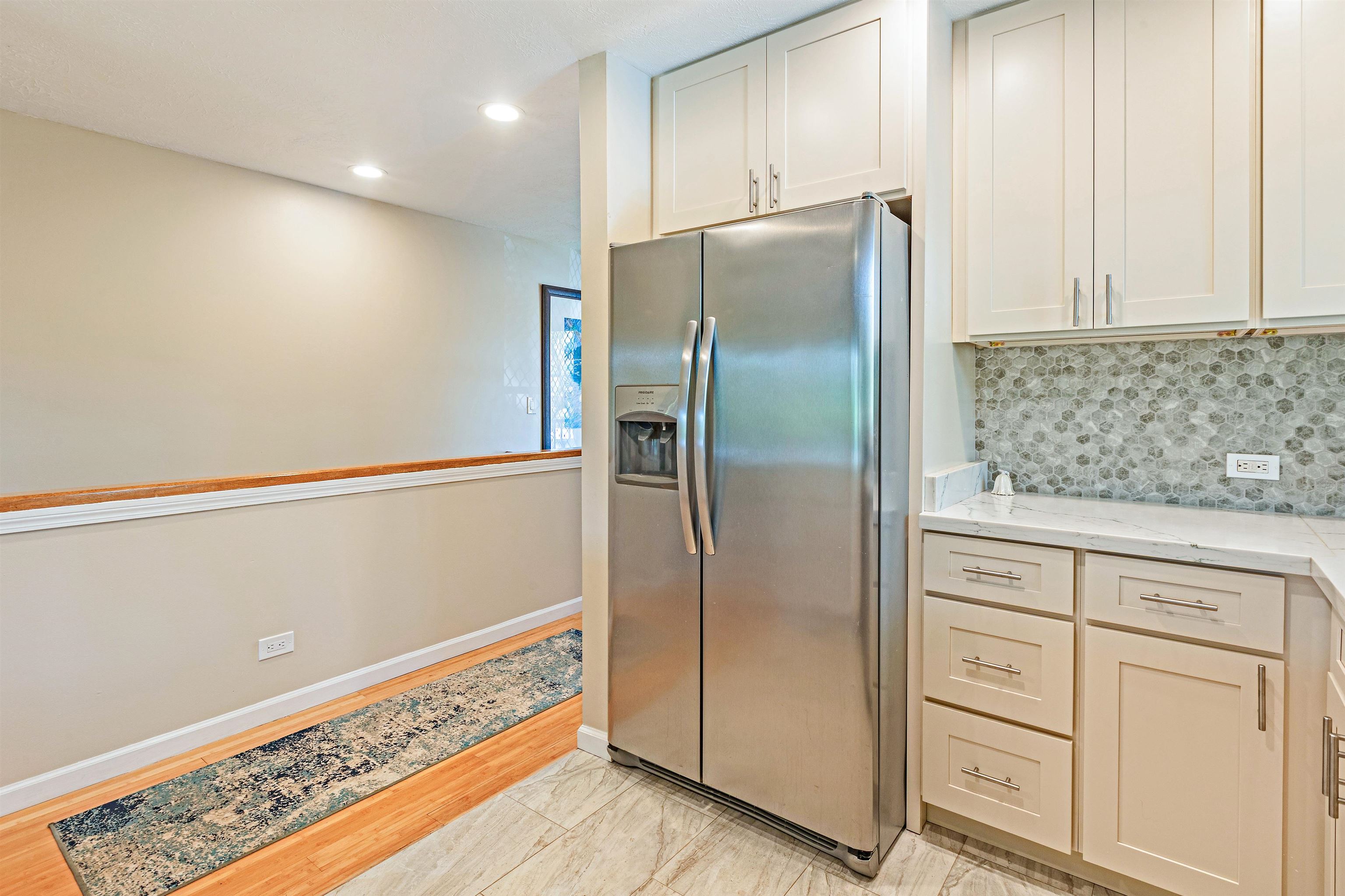 3788 Lower Honoapiilani Road, Unit D101 Lahaina, HI 96761 - Photo 12 of 40 a kitchen with white cabinets and stainless steel appliances