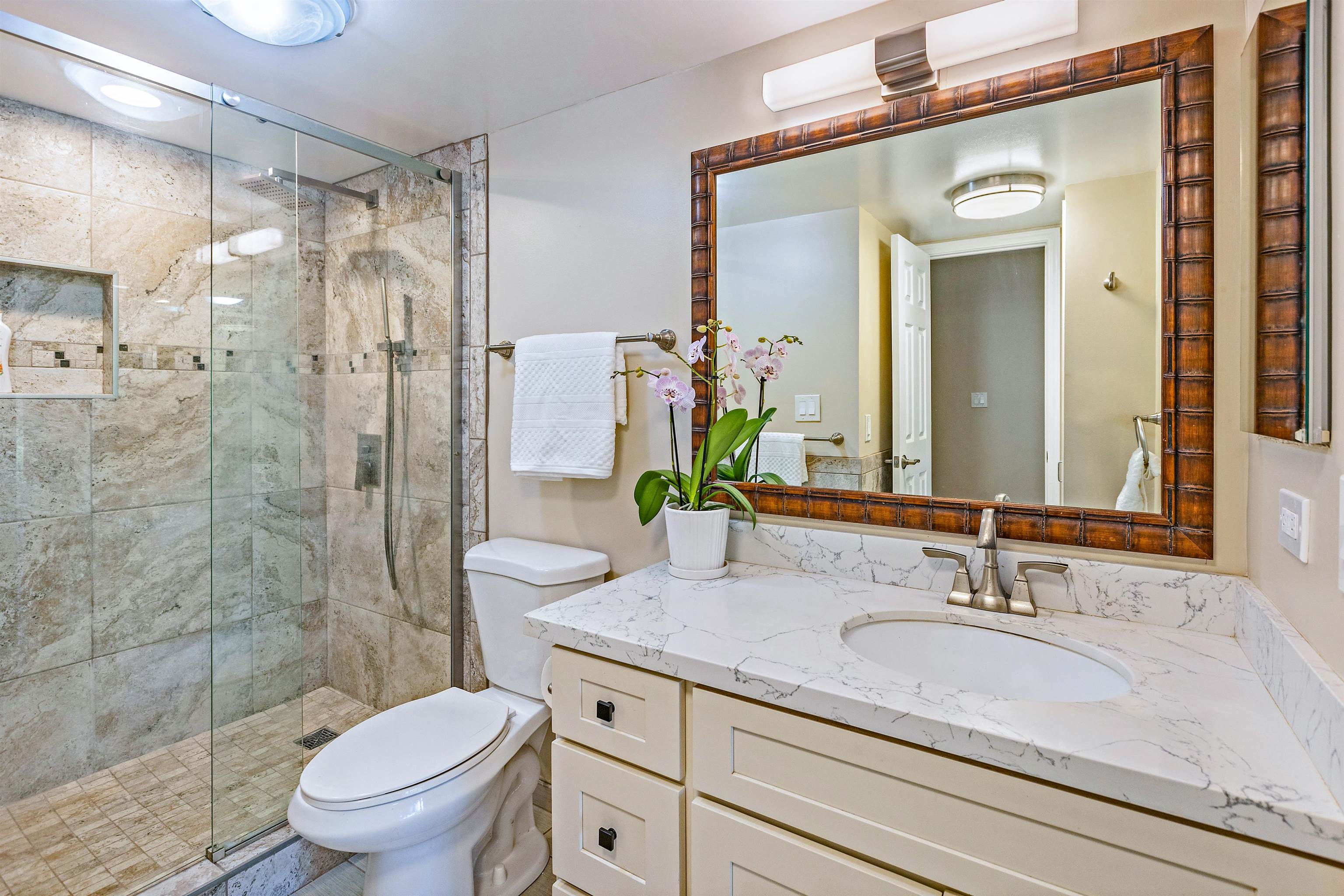 3788 Lower Honoapiilani Road, Unit D101 Lahaina, HI 96761 - Photo 19 of 40 a bathroom with a granite countertop sink toilet a mirror and shower