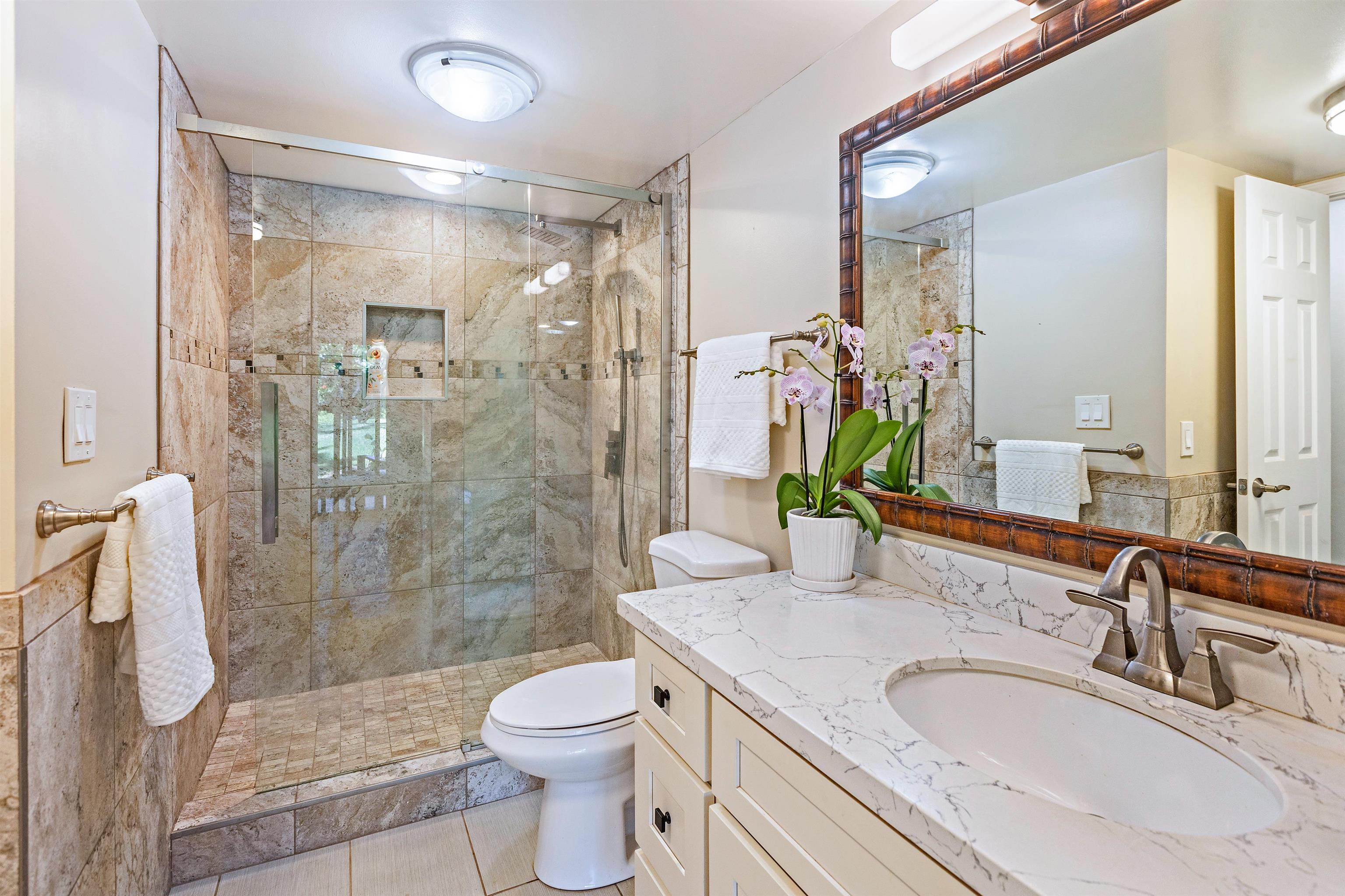 3788 Lower Honoapiilani Road, Unit D101 Lahaina, HI 96761 - Photo 20 of 40 a bathroom with a granite countertop sink toilet and shower