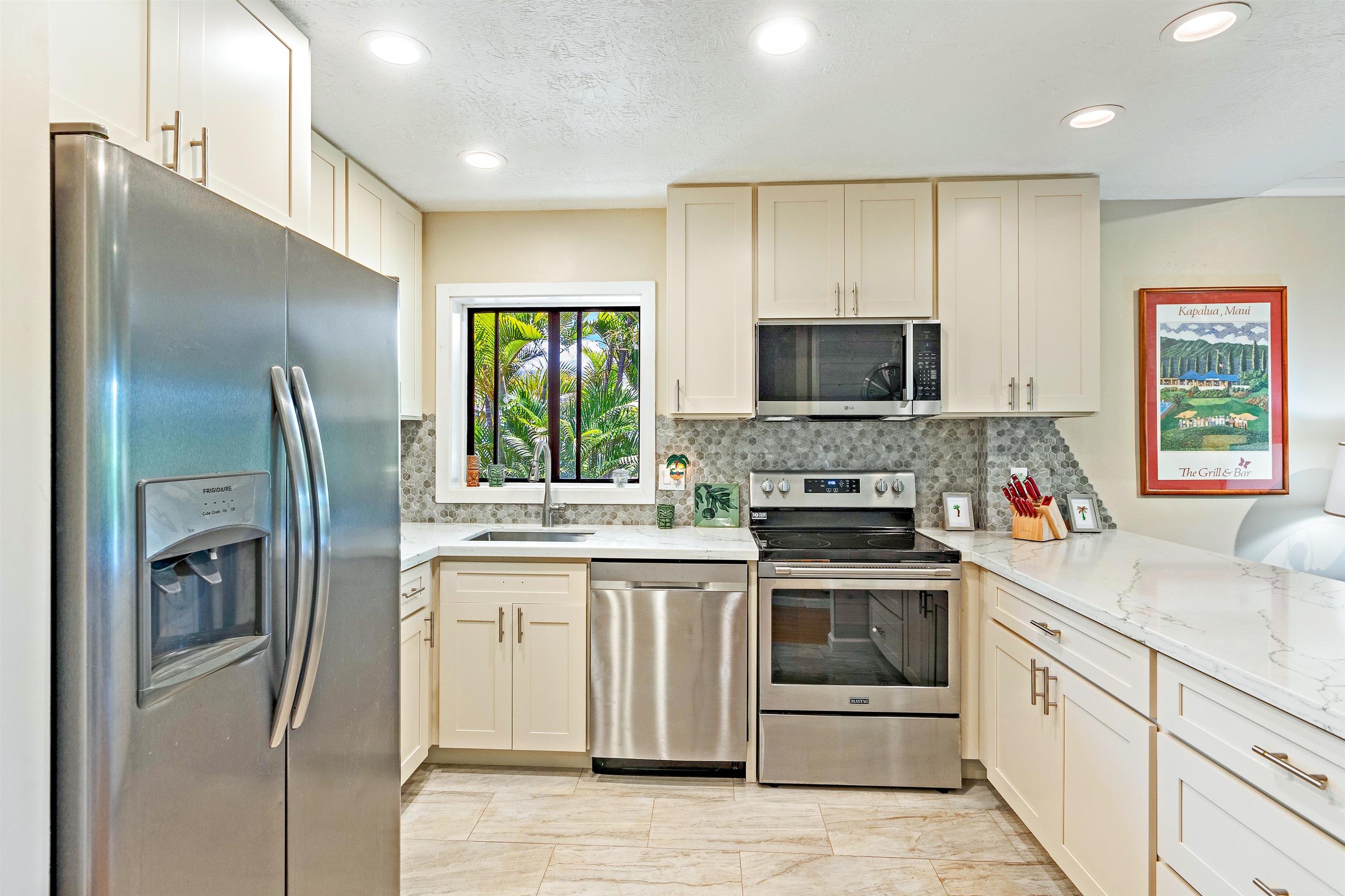 3788 Lower Honoapiilani Road, Unit D101 Lahaina, HI 96761 - Photo 3 of 40 a kitchen with stainless steel appliances granite countertop a stove a refrigerator and a sink