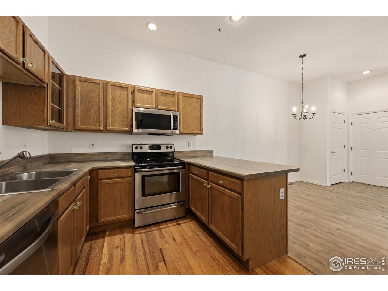 4500 Seneca Street, Unit 71 Fort Collins, CO 80526 - Photo 14 of 37 a kitchen with granite countertop a stove a sink and a microwave