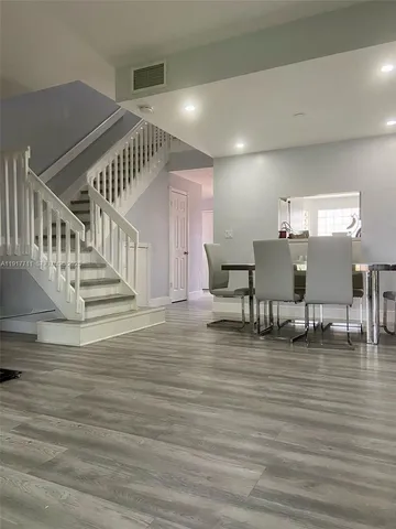 a view of dining room and livingroom with furniture wooden floor windows and a fireplace