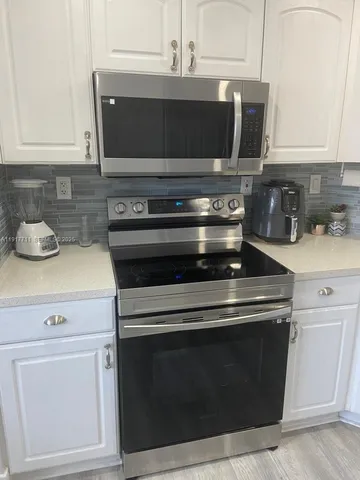 a stove top oven sitting inside of a kitchen