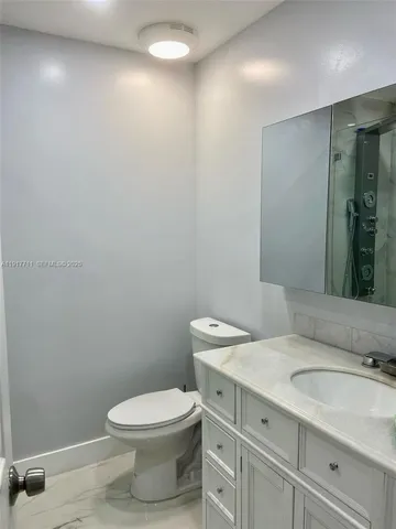 a bathroom with a toilet a sink and mirror