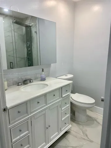 a bathroom with a toilet sink and mirror