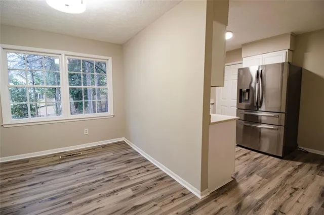 a view of a kitchen with wooden floor and electronic appliances