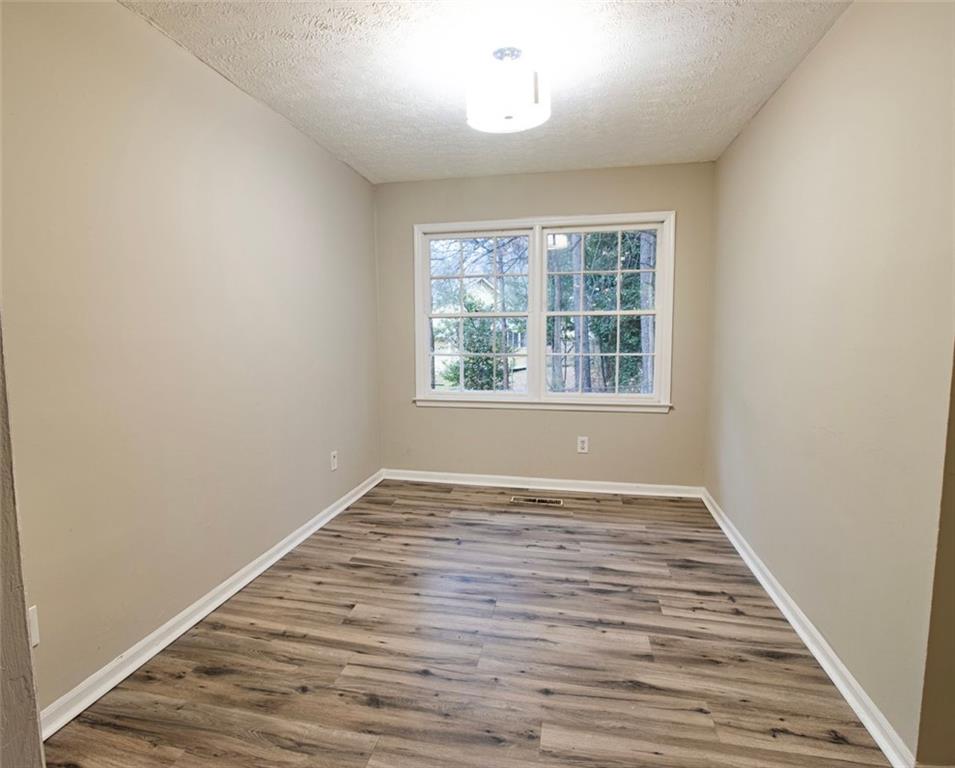 321 Tarragon Way Southwest Atlanta, GA 30331 - Photo 5 of 15 an empty room with wooden floor and windows