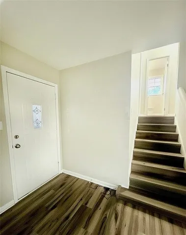 a view of a room with wooden floor and white walls