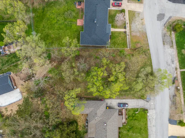 an aerial view of a residential houses with yard