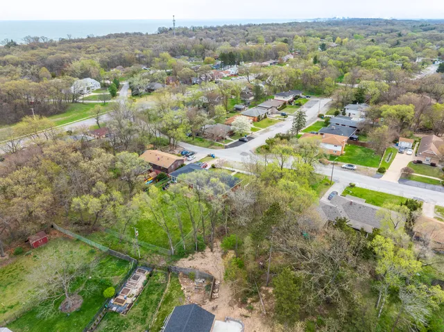 an aerial view of residential houses with outdoor space and trees