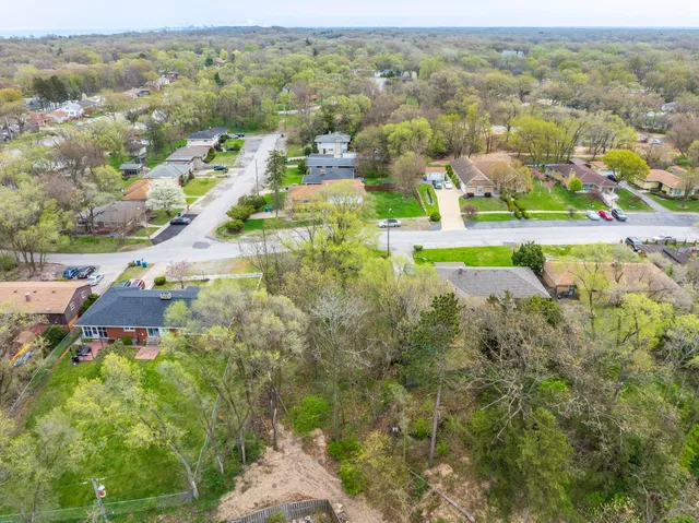 an aerial view of residential houses with outdoor space and trees