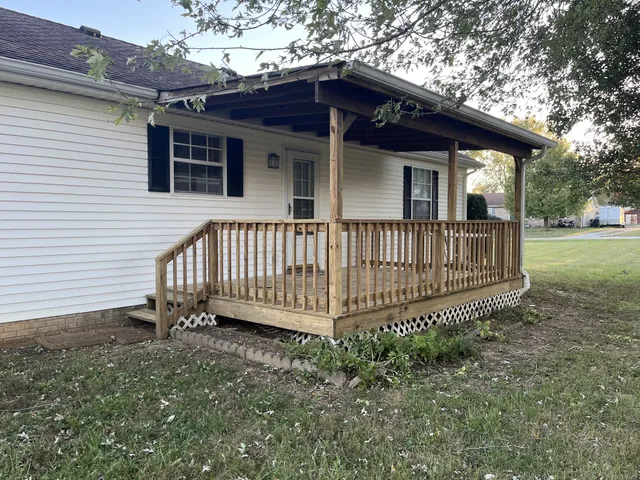 a view of a house with a yard and deck