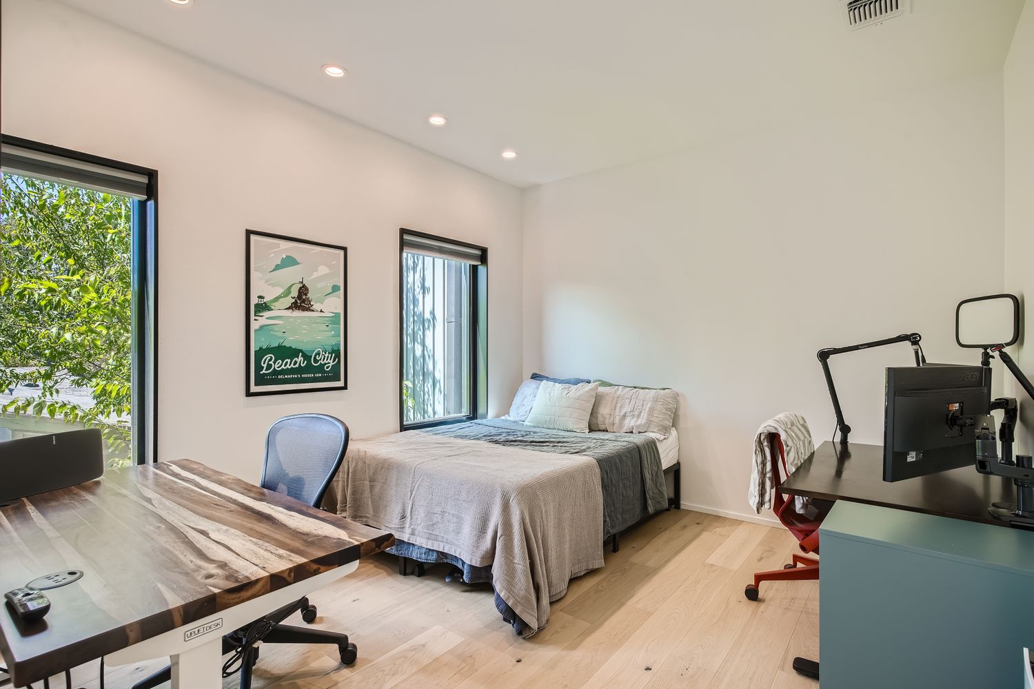 7525 Delafield Lane, Unit A Austin, TX 78752 - Photo 22 of 33 a bedroom with a bed a large window and potted plant on the table
