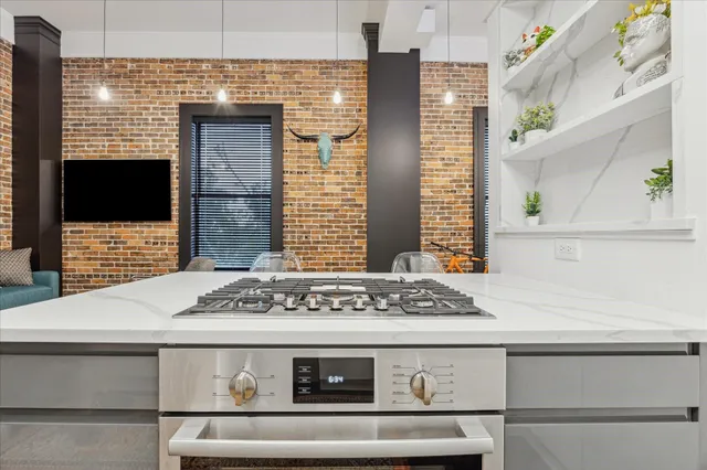 a view of kitchen with granite countertop stove top oven and cabinets
