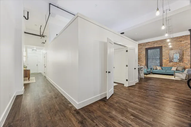 a view of a big room with wooden floor and windows