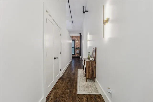 a view of a hallway with wooden floor and staircase