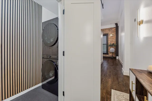 a view of a hallway with wooden floor and staircase