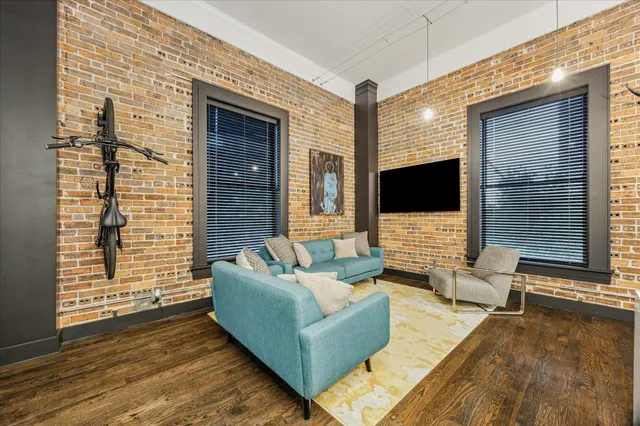 a living room with couches bookshelf and a flat screen tv