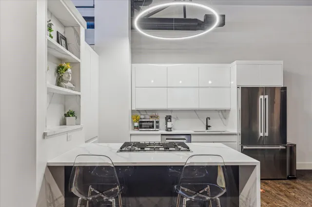 a kitchen with a stove a refrigerator and a dining table