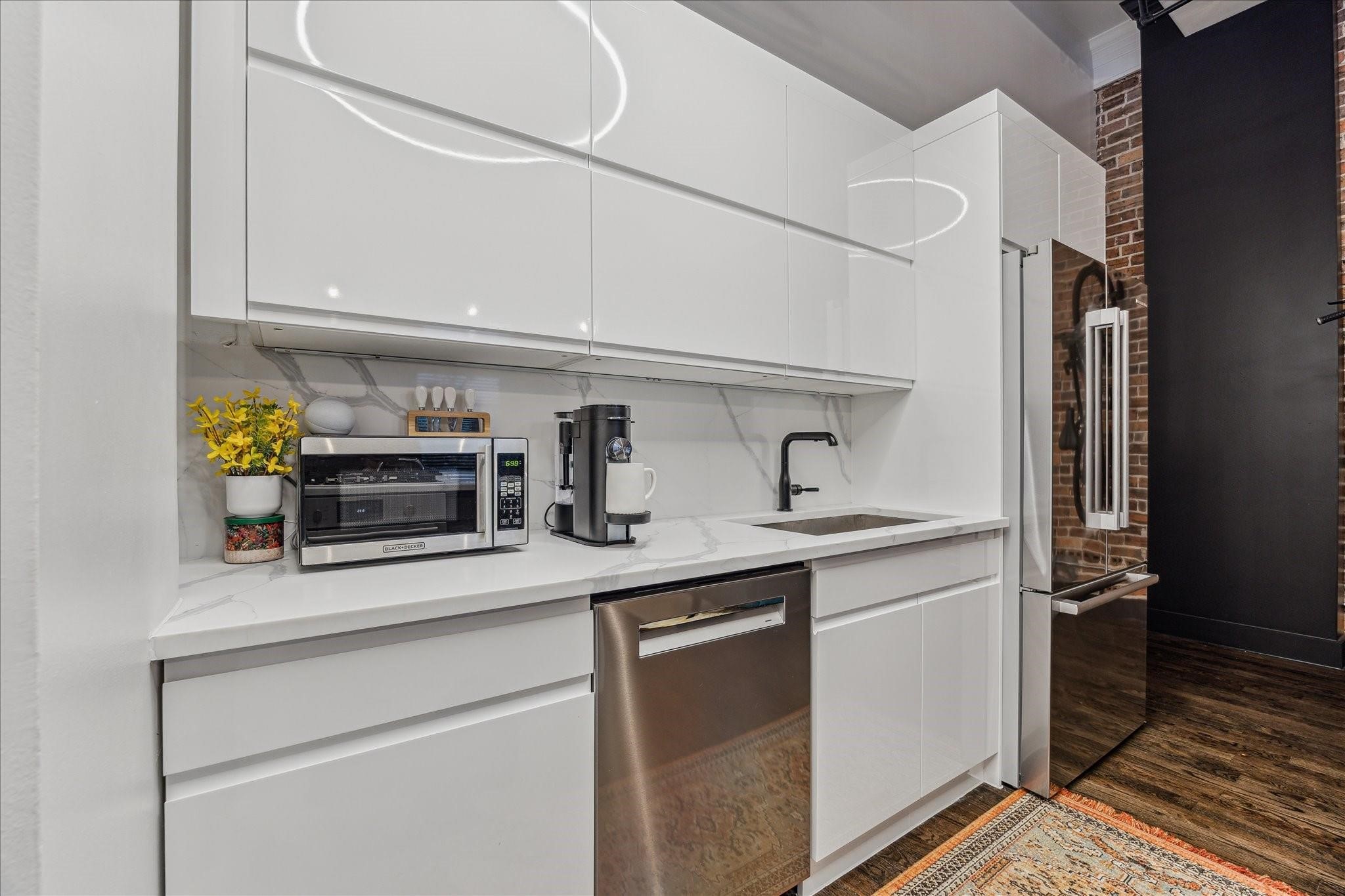 915 Franklin Street, Unit 2F Houston, TX 77002 - Photo 9 of 50 a kitchen with stainless steel appliances a sink and cabinets