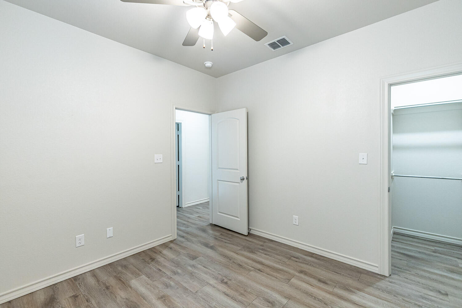 5504 Kemper Street Lubbock, TX 79416 - Photo 12 of 17 an empty room with wooden floor and hallway