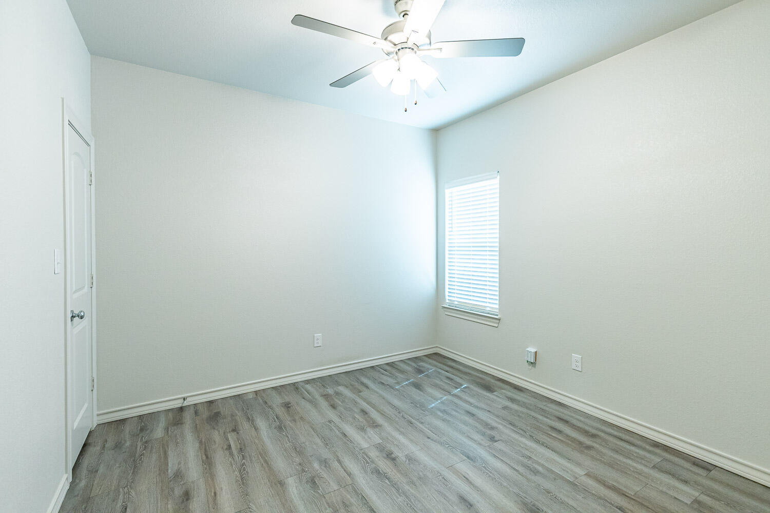 5504 Kemper Street Lubbock, TX 79416 - Photo 13 of 17 an empty room with a window and ceiling fan