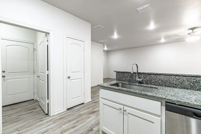 an empty room with wooden floor and ceiling fan