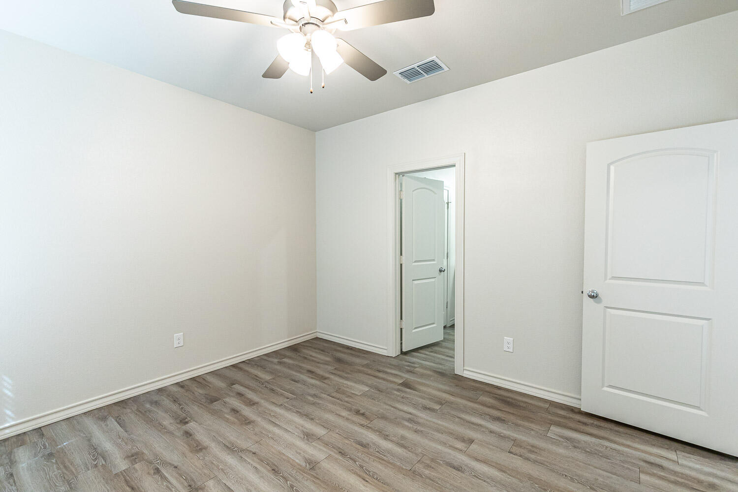 5504 Kemper Street Lubbock, TX 79416 - Photo 9 of 17 an empty room with wooden floor fan and windows